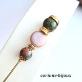 broche à chapeau également utilisée en broche pour attacher une écharpe. Composée de pierre d'unakite, une pierre fine dans les tons vert kaki et de pierre de lune saumon. Chaque perle est séparée d'éléments en métal doré pour donner de l'éclat à la broche. Pièce unique fait main sur Beynes dans les Yvelines.