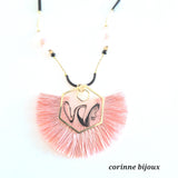 Gros plan du pendentif en forme d'éventail composé de fil rose et monté sur un support en résine.
