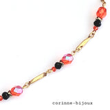 collier en céramique rouge et dorée peinte à la main. Collier monté sur chaine torsadée en acier inoxydable dorée, complété de perles en verre rouge et noir. Collier fait main. Modèle unique fait à Beynes dans les Yvelines.
