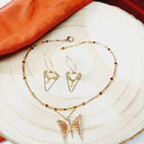 Parure de bijoux composées d'un collier en perles de verre, d'un pendentif en laiton orange en forme de papillon et assorties de boucles d'oreilles pendantes en métal doré et de perles range. Cet ensemble de bijoux fantaisie est élégant,unique,léger et original. Ces bijoux sont crées dans les Yvelines à Beynes.