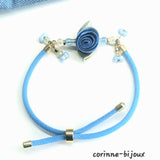 bracelet artisanal en cordon bleu avec une fleur bleu en satin et systeme coulissant ajustable