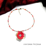 collier artisanal composé de perles dorées et rouges, orné d'un pendentif fleur en satin rouge sur support doré en résine