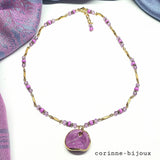 Collier en céramique peinte à la main couleur violet et bordure dorée. Collier monté sur chaine torsadée dorée en acier inoxydable. Perles en verre violet et mauve. Collier unique fait main à Beynes dans les Yvelines.