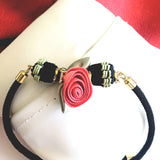 bracelet fleur rose rouge avec perles tressees noir et vert