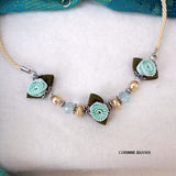 collier fait main composé d'un cordon torsadé écru, orné de 3 fleurs en passementerie vert clair et de perles blanches nacrées